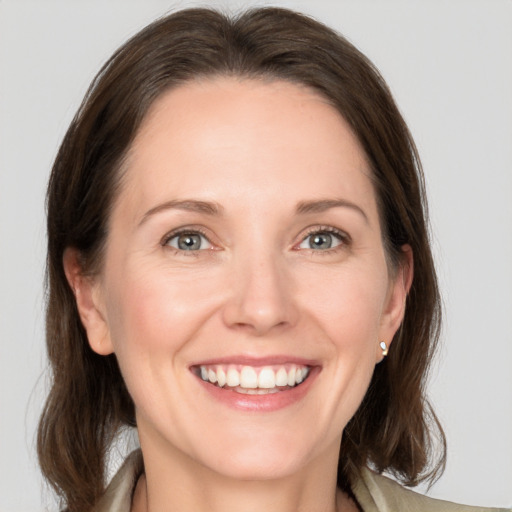 Joyful white adult female with medium  brown hair and grey eyes