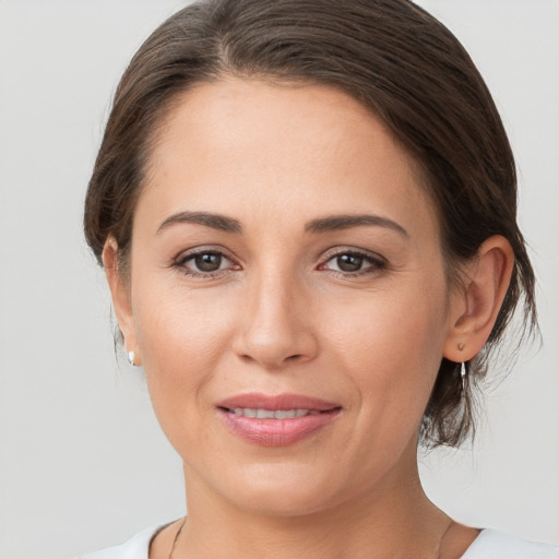 Joyful white young-adult female with medium  brown hair and grey eyes