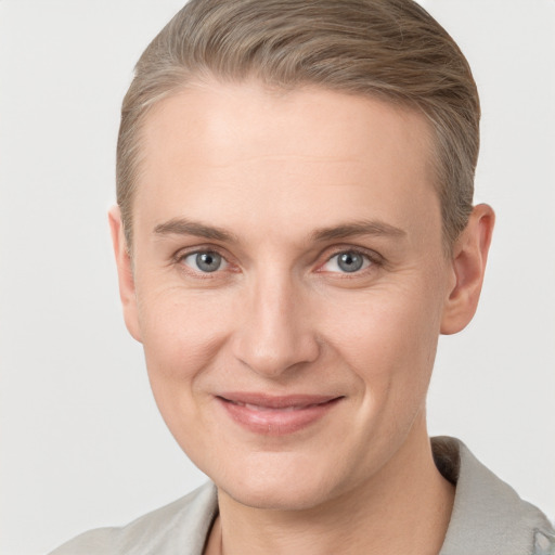 Joyful white young-adult female with short  brown hair and grey eyes