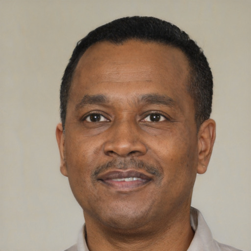 Joyful black adult male with short  black hair and brown eyes