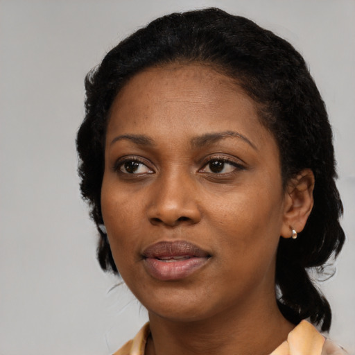 Joyful black adult female with medium  black hair and brown eyes