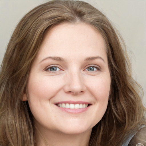 Joyful white young-adult female with long  brown hair and grey eyes