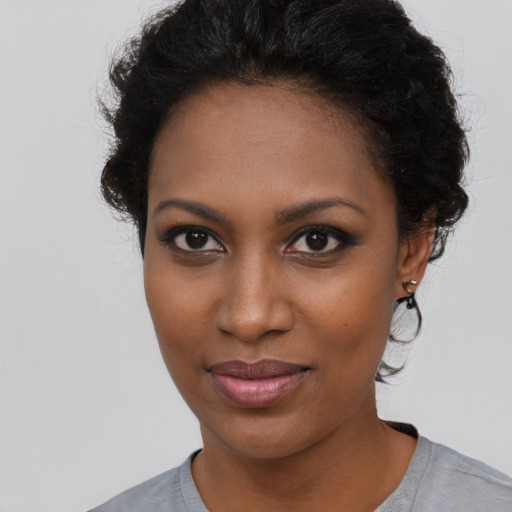 Joyful black young-adult female with short  black hair and brown eyes