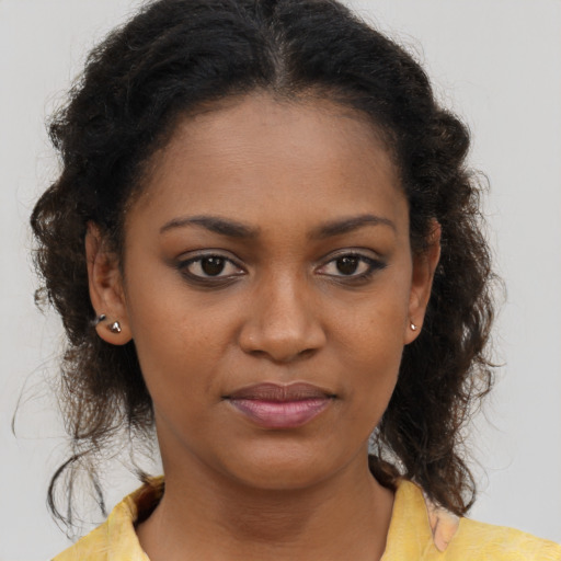 Joyful black young-adult female with medium  brown hair and brown eyes