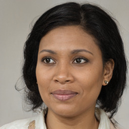 Joyful black adult female with medium  brown hair and brown eyes