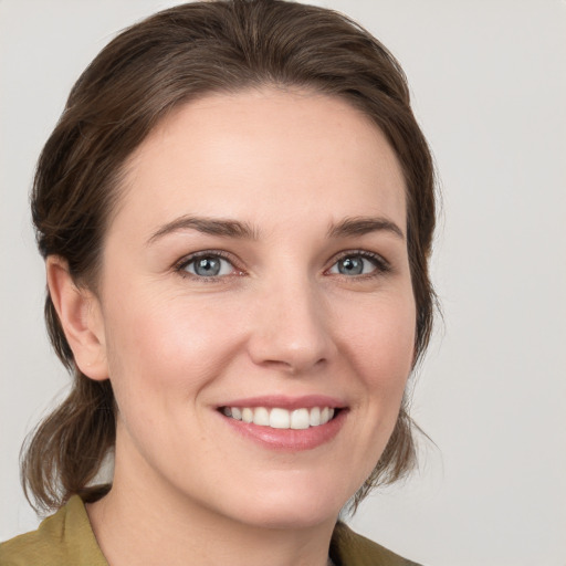 Joyful white young-adult female with medium  brown hair and grey eyes