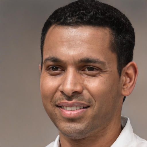 Joyful black adult male with short  black hair and brown eyes