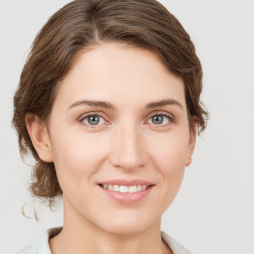 Joyful white young-adult female with medium  brown hair and grey eyes