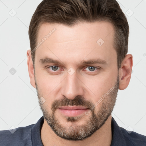 Joyful white young-adult male with short  brown hair and grey eyes