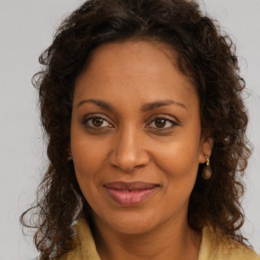 Joyful black young-adult female with long  brown hair and brown eyes