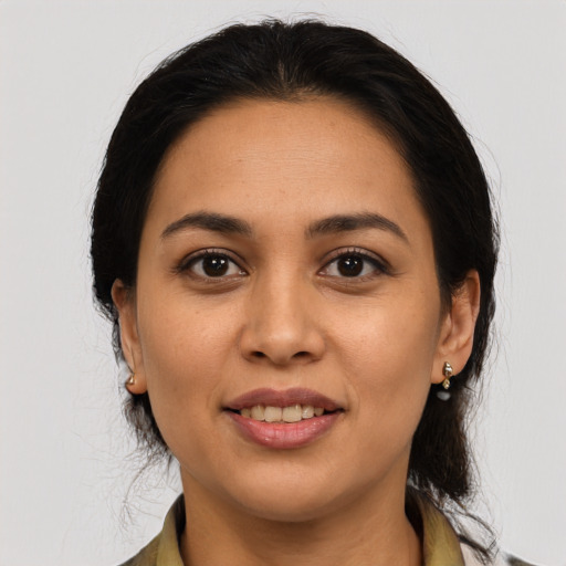 Joyful latino young-adult female with medium  brown hair and brown eyes