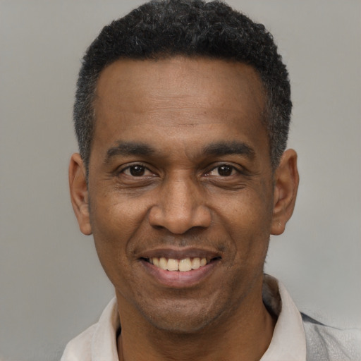 Joyful black young-adult male with short  black hair and brown eyes