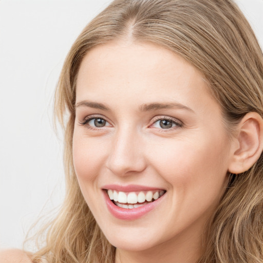 Joyful white young-adult female with long  brown hair and blue eyes