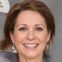 Joyful white adult female with medium  brown hair and grey eyes