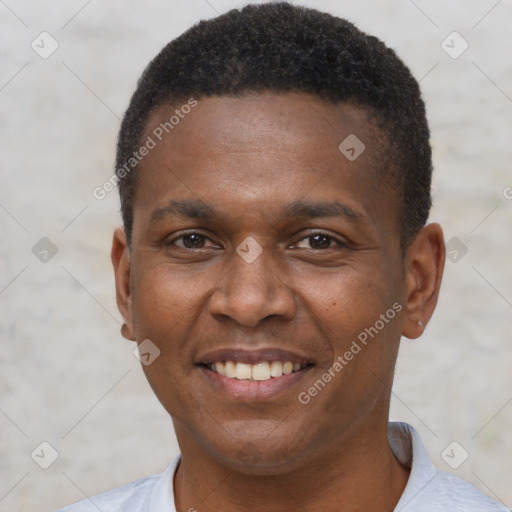 Joyful black young-adult male with short  brown hair and brown eyes