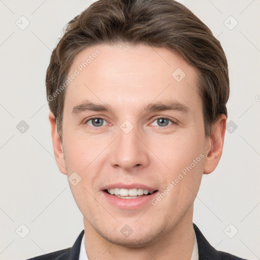 Joyful white young-adult male with short  brown hair and grey eyes