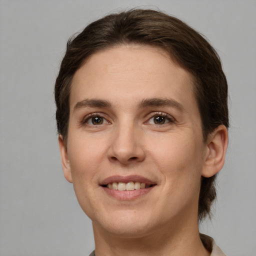 Joyful white young-adult female with short  brown hair and grey eyes