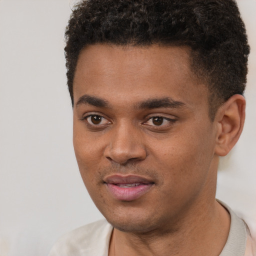 Joyful black young-adult male with short  black hair and brown eyes
