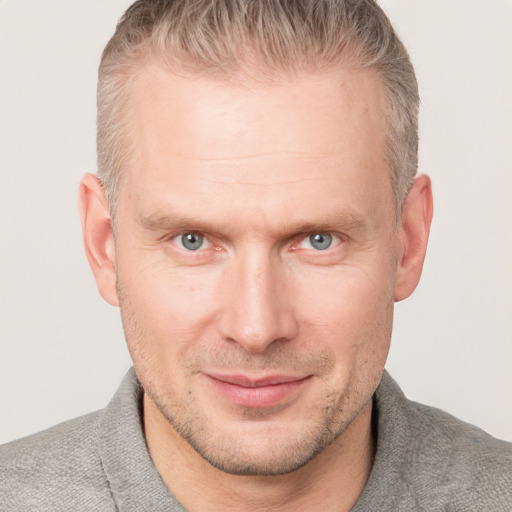 Joyful white adult male with short  brown hair and grey eyes