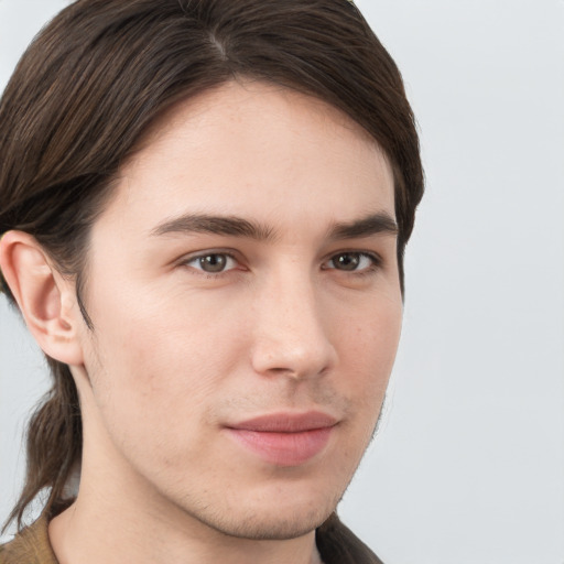 Joyful white young-adult male with long  brown hair and brown eyes