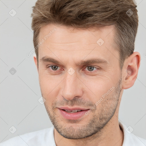 Joyful white young-adult male with short  brown hair and brown eyes