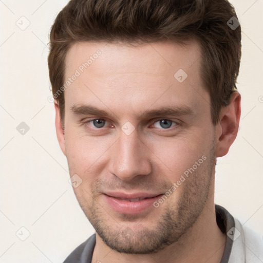 Joyful white young-adult male with short  brown hair and grey eyes