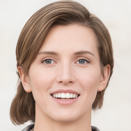 Joyful white young-adult female with medium  brown hair and green eyes