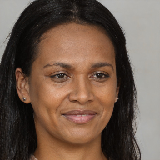 Joyful black adult female with long  brown hair and brown eyes