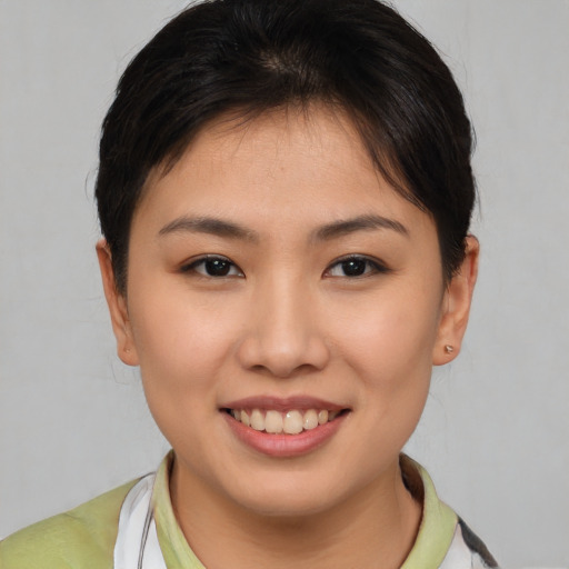 Joyful asian young-adult female with short  brown hair and brown eyes