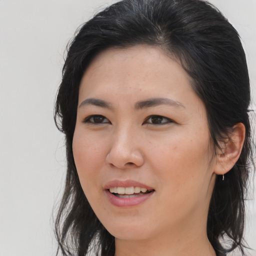 Joyful asian young-adult female with long  brown hair and brown eyes
