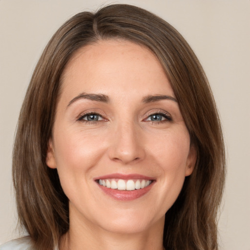 Joyful white young-adult female with medium  brown hair and green eyes