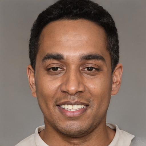 Joyful black young-adult male with short  black hair and brown eyes