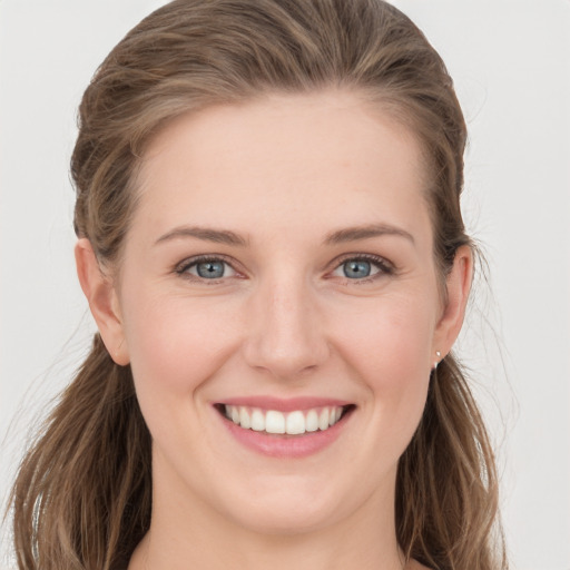 Joyful white young-adult female with long  brown hair and grey eyes