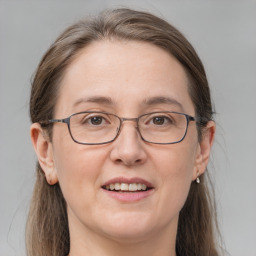 Joyful white adult female with long  brown hair and grey eyes