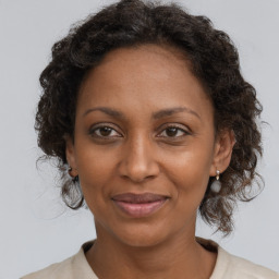 Joyful black adult female with medium  brown hair and brown eyes