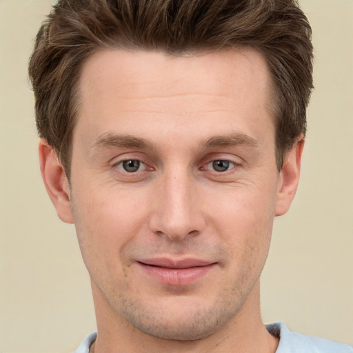 Joyful white young-adult male with short  brown hair and grey eyes