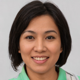 Joyful white young-adult female with medium  brown hair and brown eyes