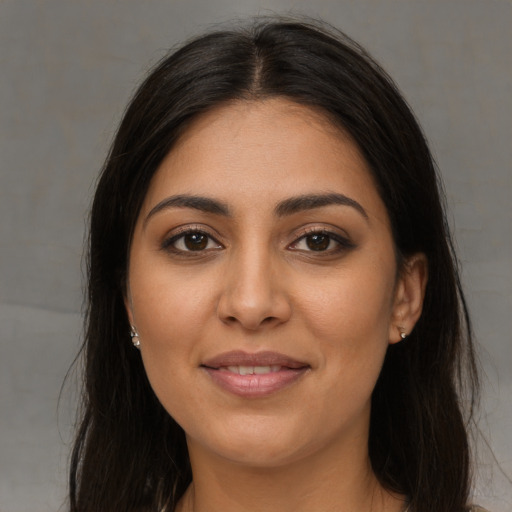 Joyful latino young-adult female with long  brown hair and brown eyes