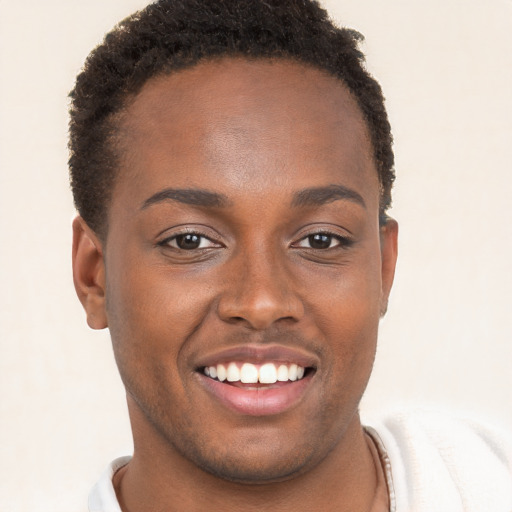 Joyful black young-adult male with short  brown hair and brown eyes