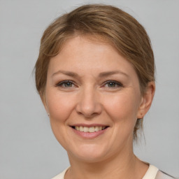 Joyful white adult female with medium  brown hair and brown eyes