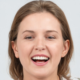 Joyful white young-adult female with medium  brown hair and grey eyes