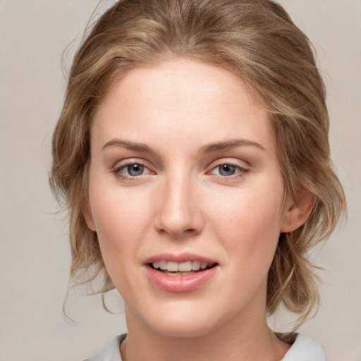 Joyful white young-adult female with medium  brown hair and blue eyes