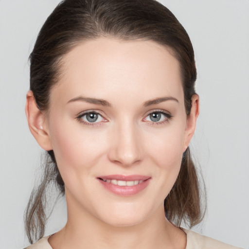 Joyful white young-adult female with medium  brown hair and grey eyes