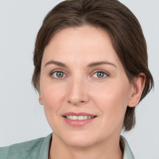 Joyful white adult female with medium  brown hair and grey eyes