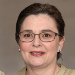 Joyful white adult female with medium  brown hair and blue eyes