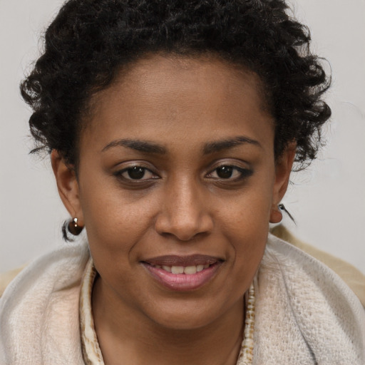 Joyful black young-adult female with short  brown hair and brown eyes