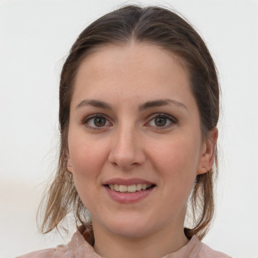 Joyful white young-adult female with medium  brown hair and grey eyes