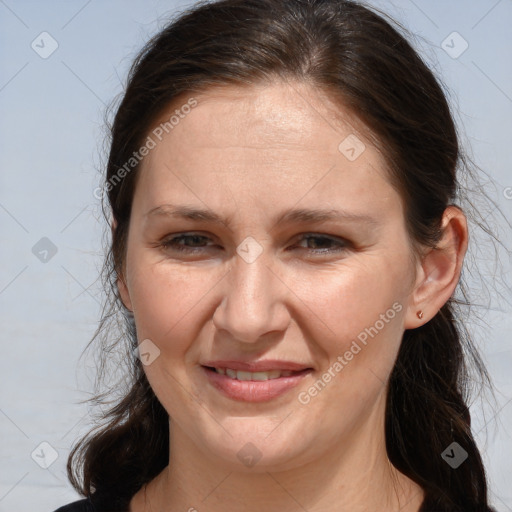 Joyful white adult female with long  brown hair and brown eyes