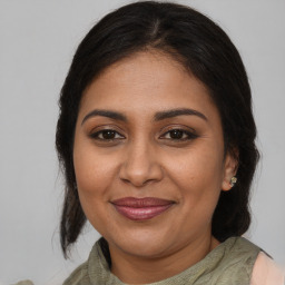 Joyful black adult female with medium  brown hair and brown eyes