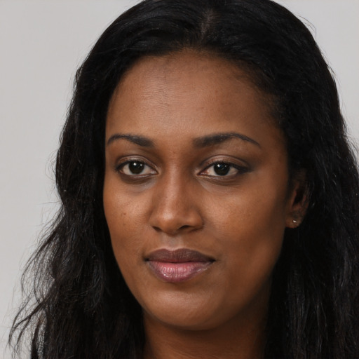 Joyful black young-adult female with long  black hair and brown eyes